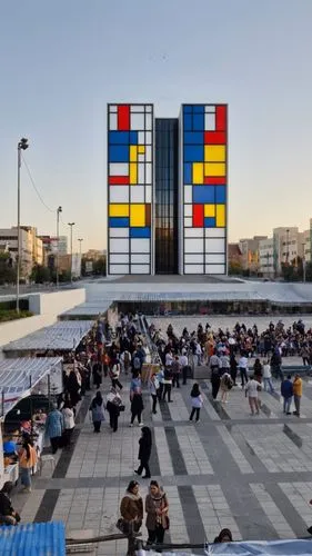 large windowsuureal tower based on  The Mondrian art style, ,people walk on a city square with a building in the background,macba,mondrian,documenta,dizengoff,shipping containers,zadar,champalimaud,mo