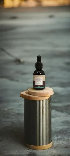 a small bottle on a wooden shelf next to a cup,isolated bottle,urethane,isolated product image,thermos,pill bottle,cosmetic oil