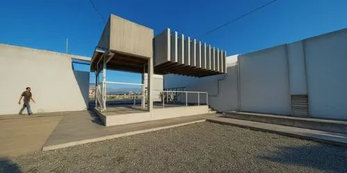 AREA DE CONVIVENCIA, CON PERGOLAS DE CONCRETO, LOSA CON REMATE DE VIGA DE ACERO, ESPEJO DE AGUA ,the man is walking out from a white building,siza,cubic house,moneo,corbu,cantilevered,associati,Photog