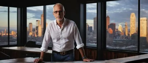 Peter Frampton, mature man, 50yo, short brown hair, glasses, beard, white shirt, dark blue jeans, black leather belt, standing, leaning on a desk, architectural studio, modern interior, wooden floors,