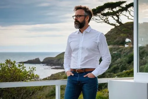 Mature male architect, 30s, short brown hair, glasses, beard, white shirt, dark blue jeans, black boots, holding a blueprint, standing in front of a Cornish seaside villa, modern minimalist design, la