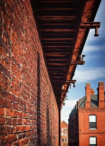 Architectural brick wall section detail, close-up shot, red bricks, mortar joints, weathered texture, rusty steel beams, industrial pipes, urban atmosphere, modern cityscape, afternoon sunlight, warm 