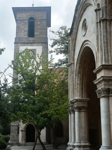 Romanesque-style church (round arches only).,a large tall tower next to a tree,sanctuary of sant salvador,santa maria degli angeli,panagia,ariccia,colonna dell'immacolata,kykuit