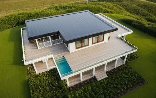 Small modern house surrounded by a cottage community.
The walls are white. Black roof.,the view from above of a house with large lawn,solarcity,grass roof,weatherboards,passivhaus,weatherboard,turf ro