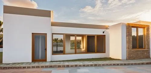 Mantener la paleta de colores y ventanas y tambien la textura de piedra y pavimento de concreto y con luz natural,a white house with brown trim next to grass and flowers,dunes house,umhlanga,holiday v