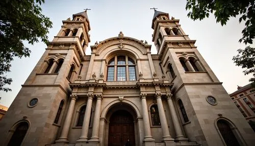 Grandiose church facade, ornate stone carvings, symmetrical composition, soaring bell towers, intricate stained glass windows, majestic entrance archways, rusticated quoins, Corinthian columns, decora