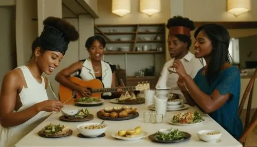 A group of real people sitting at a dining table, one person holding a guitar and singing while others are enjoying a dining table,some people are sitting at a table eating some food,beautiful african