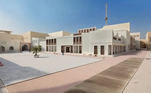 Construction school renovated building, saudi arabia, dawasir, heritage context, piazza with construction educational activities, sandstone walkway,two buildings are in a courtyard in a city,masdar,qa