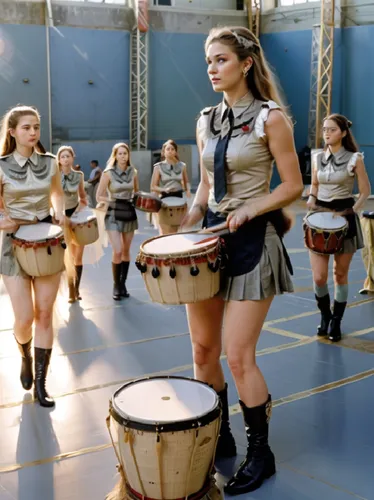 the girls are in uniform playing drums in formation,batala,haka,leonas,drumline,majorettes,bongos