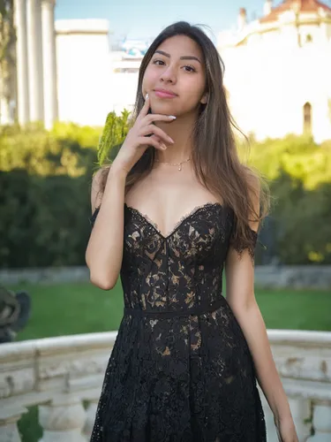 She is wearing a black lace dress, background is outside,black dress,in a black dress,quinceañera,a girl in a dress,little black dress,black and lace,vintage dress,azerbaijan azn,black dress with a sl