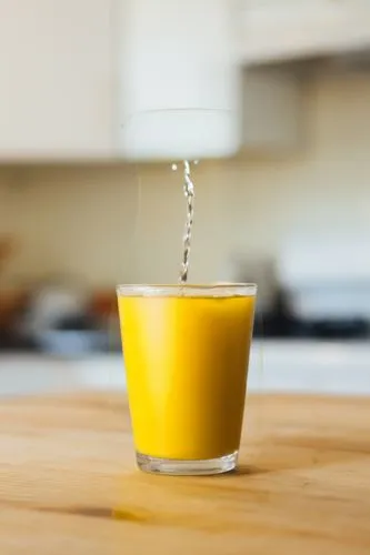 cup of water,a glass that is filled with soing sitting on a table,fresh orange juice,sweetened condensed milk,orange juice,oj,advocaat,egg yolk,aioli,egg yolks,vegetable juice,yellow cups,curcumin,las