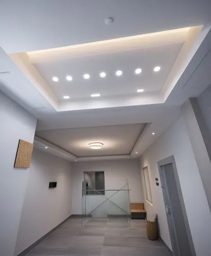 a minimalist modern design that matches the color of the gray floor tiles,a very large room with lots of light in it,ceiling lighting,ceiling construction,ceiling light,concrete ceiling,stucco ceiling