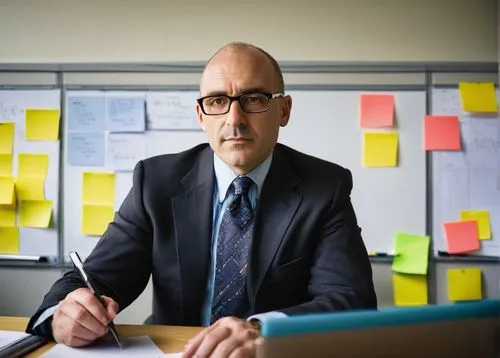 Software architect, middle-aged man, glasses, balding hair, suit, tie, sitting, office chair, desk, laptop, papers, pens, sticky notes, whiteboard, markers, modern office interior, bright lighting, 3/