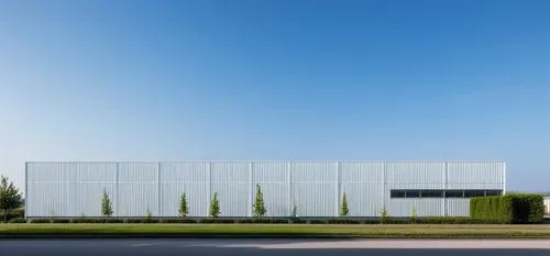 industrial warehouse with corrugated metal sheet facade, trees around the building
,glass facade,siza,epfl,metal cladding,saclay,gensler,archidaily,aqua studio,architectes,adjaye,vitra,champalimaud,mo