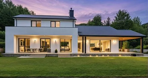 A minimalist Scandinavian-style house featuring large windows with sleek black frames and a few stone accents on some of the pillars. The house has a glass balcony that enhances its modern, open feel.