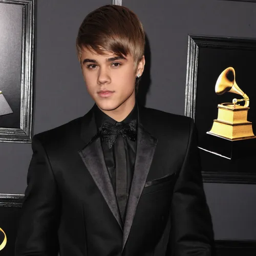 Singer Justin Bieber arrives at The 53rd Annual GRAMMY Awards held at Staples Center on February 13, 2011 in Los Angeles, California.,justin bieber,award background,music artist,black suit,golden reco