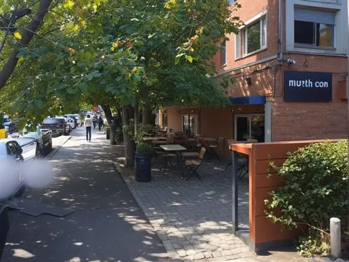  Photo of an outdoor bar in the city center, on the sidewalk with trees and plants. Wooden tables are set up under canopies. Next to it, there is another building made of red brick, near which stands 