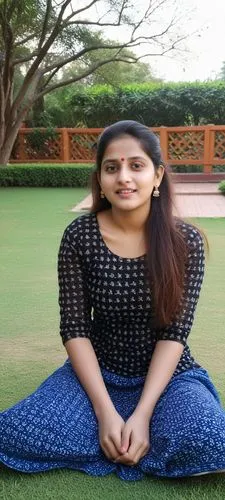 woman in jeans and black top sitting on grass with tree,vijayashanti,gautami,anasuya,bhavana,srividya,chrysomya