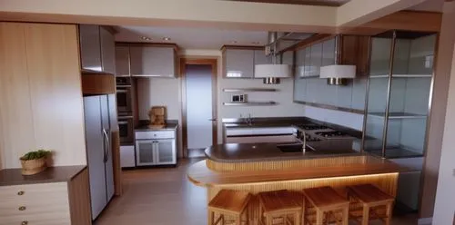 large luxurious kitchen with two color tones flush doors and drawers with profile handles. Kitchen is populated by utensils and kitchen equipment and spice jars on the shelves,a wooden table sitting i