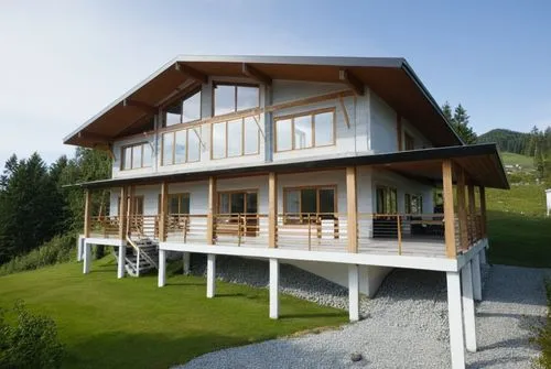 small modern house. The walls are white. Gray roof. There is a forest around the house.,a small wooden building in a lush green field,chalet,glickenhaus,nendaz,passivhaus,leogang,lohaus,Photography,Ge