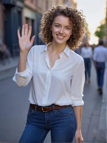 Friendly smiling woman, waving hand, casual standing pose, bright blue eyes, curly brown hair, light makeup, white blouse, dark blue jeans, sneakers, urban background, city street, sunny day, gentle w