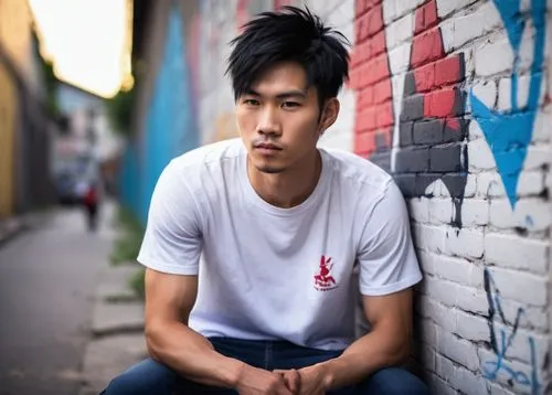 Hop Wei, Asian male, late 20s, athletic build, messy black hair, sharp facial features, strong jawline, small nose ring, casual wear, white graphic t-shirt, dark blue skinny jeans, red and white sneak