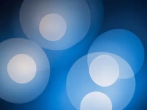 a red cell phone on top of a black surface,blue spheres,bokeh lights,bokeh pattern,blue light,bokeh,blue lamp