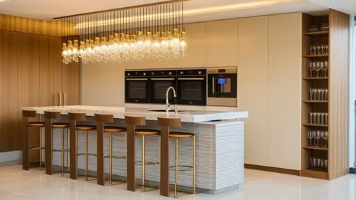 A kitchen that is a wall of tall cabinets in a light Sahara-beige shade
In the center of the cabinet wall there are 3 built-in ovens and a coffee machine similar to the ovens
A large central island wi