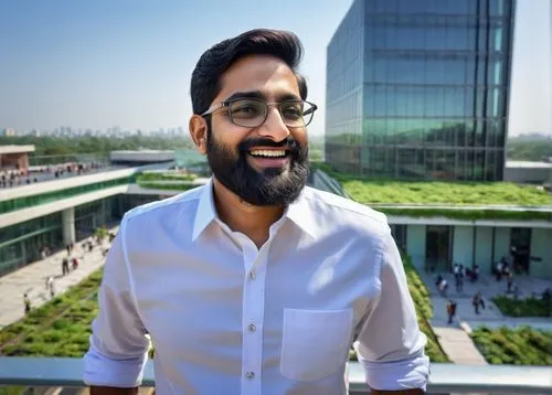 Karan Desai, Indian architect, mature man, beard, glasses, white shirt, black pants, standing, pointing, speaking, modern building, glass façade, steel structure, green roof, urban landscape, cityscap