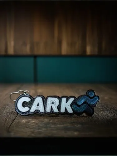 a keychain shaped like the word carr on a table,cyrk,cerrik,cari,carkeek,garki,car badge