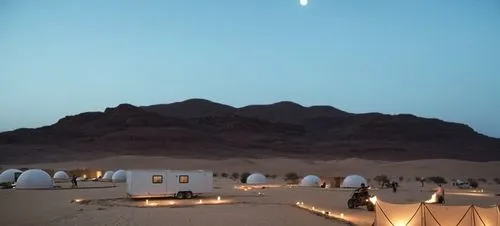 saudi arabia desert background with dumes only,a desert with tents and lights in front of a mountain,wadirum,wadi rum,moon valley,nuweiba,amanresorts,siwa