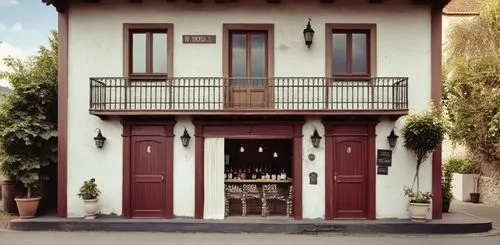 - Winebar embaixo
- Portas de madeira pintadas cor grená. 
- Toldo de lona cor azul e branco"
,an elegant, well - kept building is set on a corner,ristorante,house facade,traditional building,casalesi