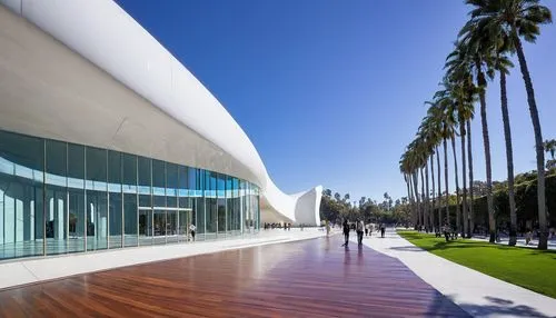 Modern architecture, design museum, Los Angeles, CA, sunny day, blue sky, white building, curved lines, glass facade, steel structure, wooden floors, exhibition hall, spotlight, sculptures, art pieces