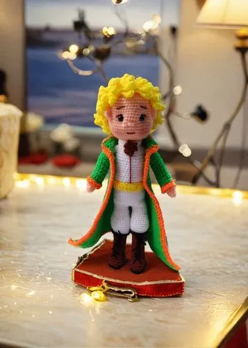 a small knit doll with blonde hair and a green cape,angel gingerbread,marzipan figures,elf on a shelf,elisen gingerbread,gingerbread boy,cutout cookie