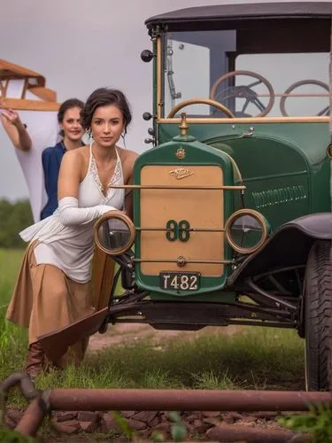 The Ford (Model T) chugs through a Texan landscape, its dark green exterior reflecting the bright sunlight. Mrs. Clara Jane Ford is at the center of the action. The intricate details of the old car im