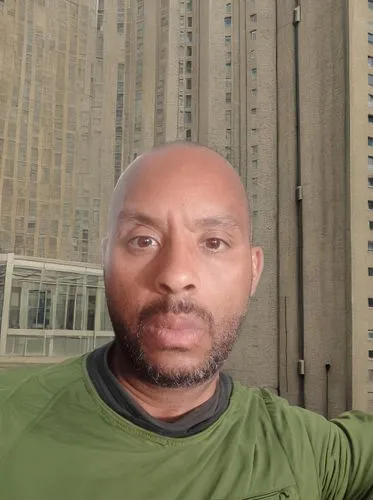 Masculino,  Orientais,  masculino, Jovem adulto, S, Confiança, Moda Masculina
Fundo Ao ar livre, Cidade Moderna,man in green shirt sitting in front of a building,ikechukwu,abdulrazak,abdoulkarim,zahra