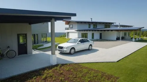 Мodern house surrounded by a forest.
The walls are white. Black roof.,a white car parked in front of an upscale house,carports,grass roof,folding roof,golf lawn,electric charging,carport,Photography,G