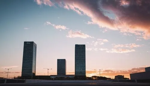 cityscape, sunset, mall, long oad, buildings, small clouds, seen from the ground horizon,the sun sets over tall buildings in the city,brasilia,majadahonda,azrieli,las torres,costanera center,zaragoza,