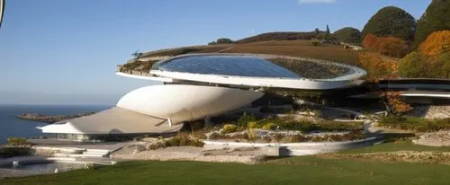 DISEÑO EXTERIOR DE UNA RESIDENCIA ESTILO FUTURISTA CON FORMA ESPACAIL ORGANICA, CON UN AMPLIO VENTANAL DE CRISTAL AL FRENTA, CON VISTA AL MAS, RODEADA DE VEGETACIÓN EXUBERANTE, CORRECION DE ERRORES, P