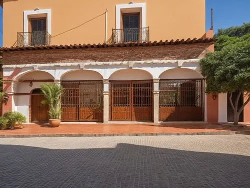 Fachada de oficinas estilo colonial utilizando materiales como el tabique y herrerías así como vegetación acorde a el estilo colonial con algunas características de hacienda,an old building with a lot