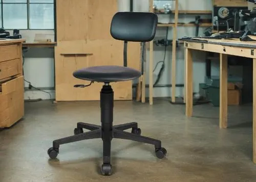 a black desk chair in a garage setting,office chair,steelcase,industrial design,new concept arms chair,sawhorses,workbenches